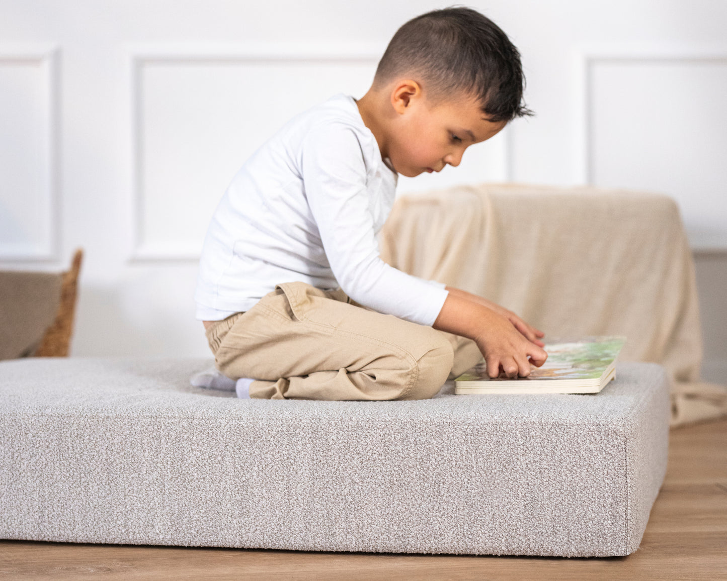 Kind sitzt lesend auf Hüpfpolster von malwim – gemütlicher Rückzugsort fürs Kinderzimmer