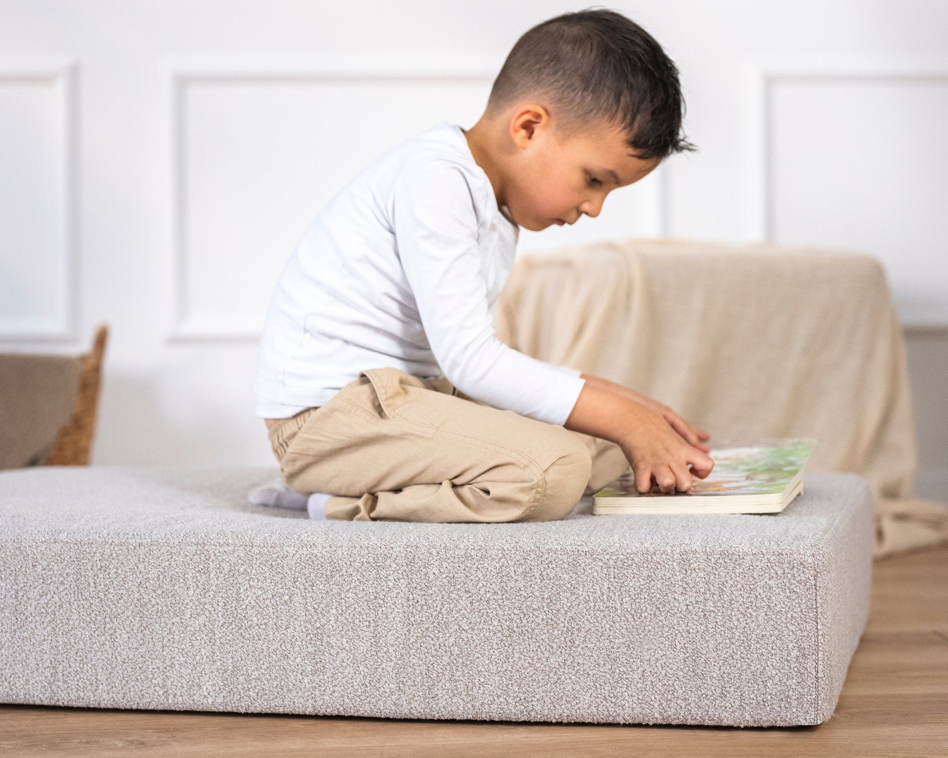 Kind sitzt lesend auf Hüpfpolster von malwim – gemütlicher Rückzugsort fürs Kinderzimmer