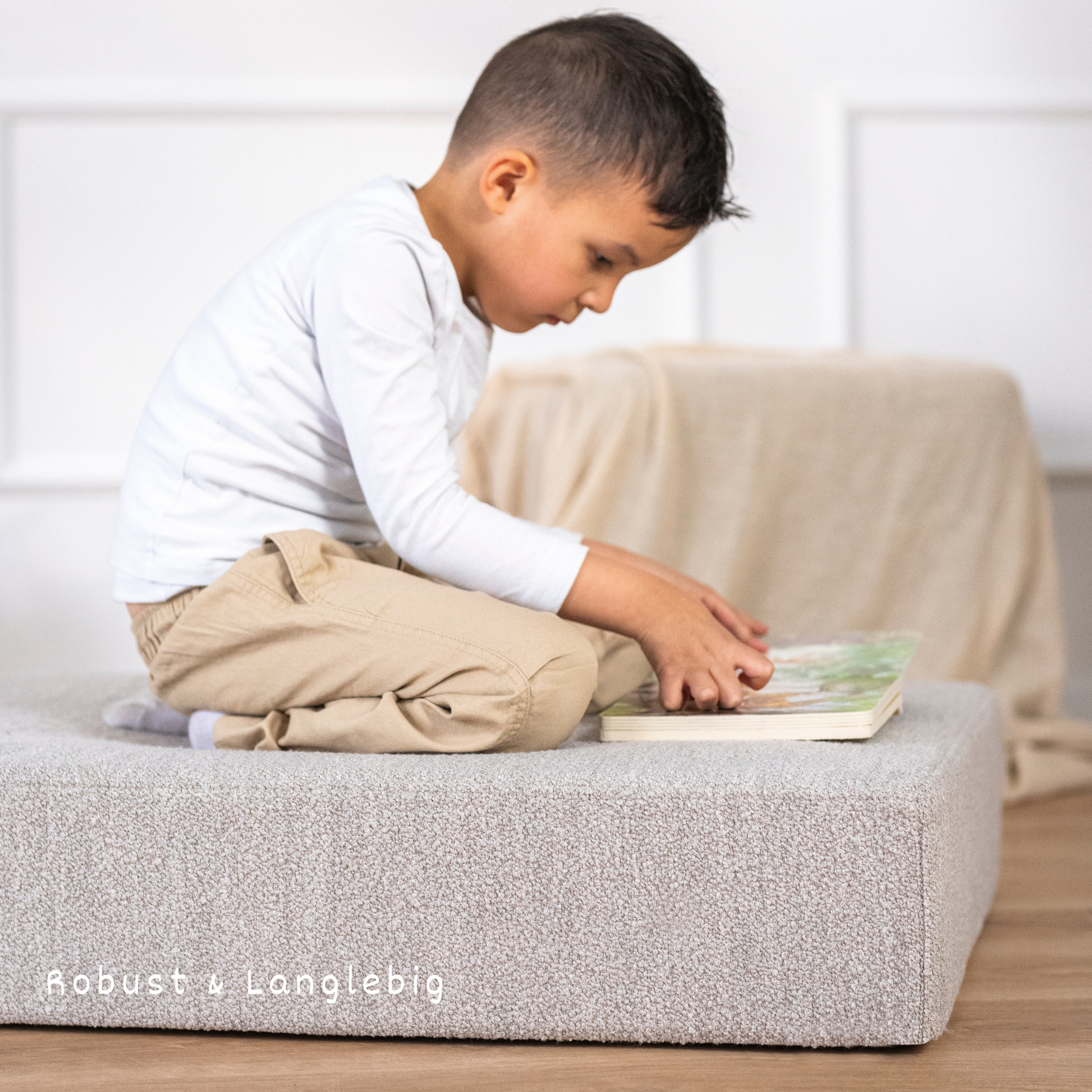 Kind spielt auf dem malwim Hüpfpolster Bouclé aus kieselnem Bouclé im Kinderzimmer


