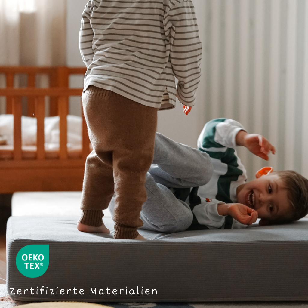 Kinder spielen auf dem malwim Hüpfpolster Cord aus mausgrauem Cord im Kinderzimmer
