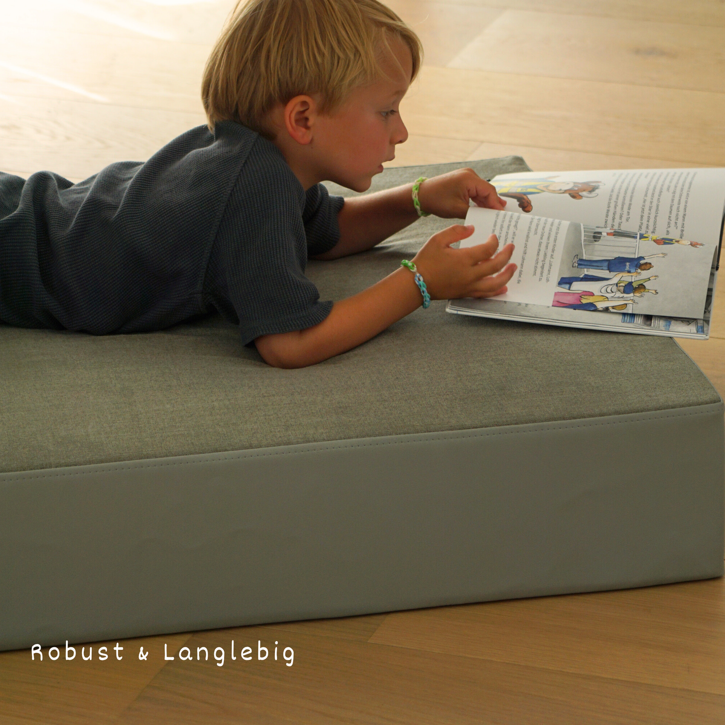 Kind spielt auf dem malwim Hüpfpolster Webstoff aus grün-grauem Webstoff im Kinderzimmer
